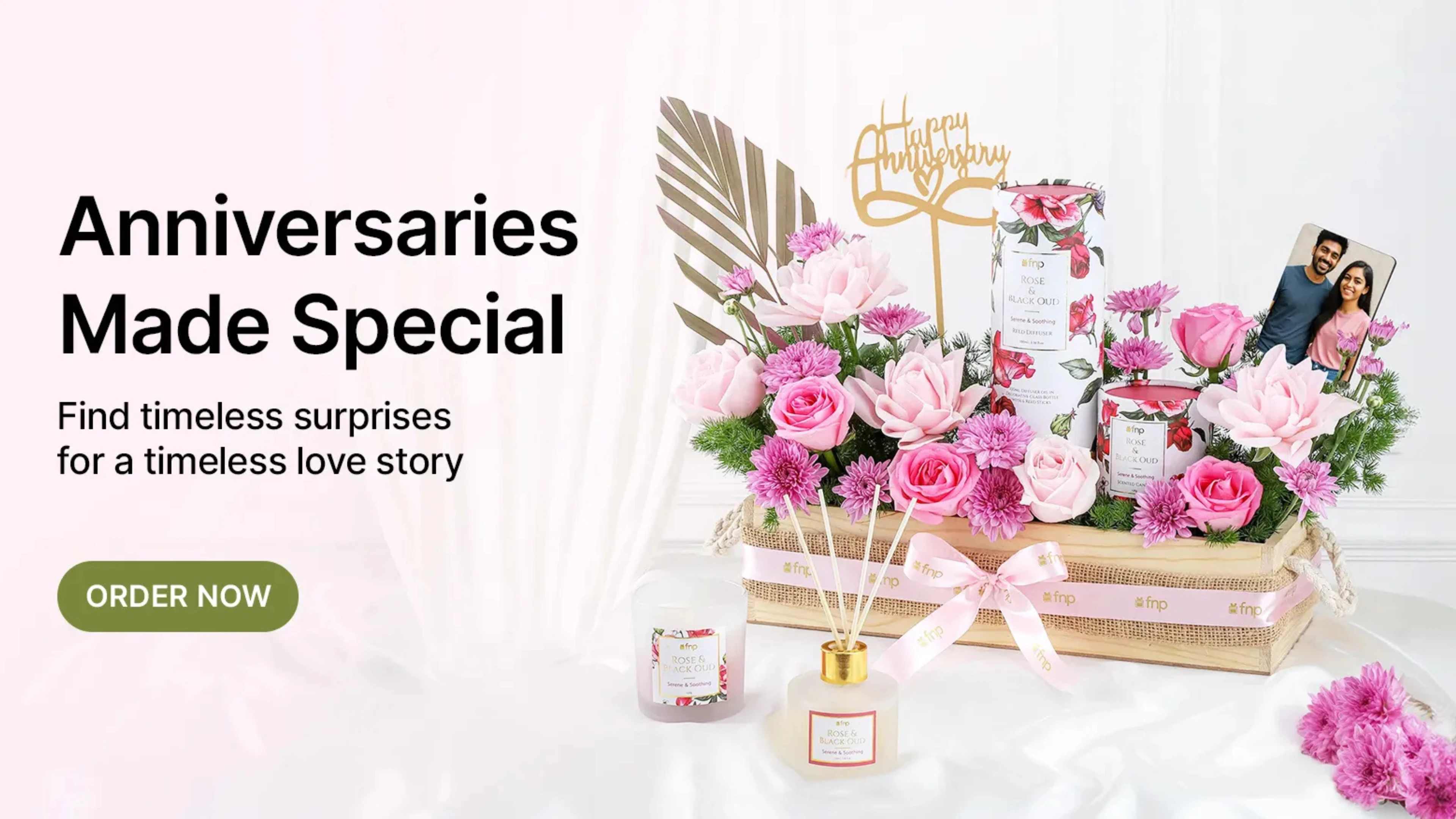 Luxury anniversary gift hamper with pink roses, personalized photo, and scented candles.